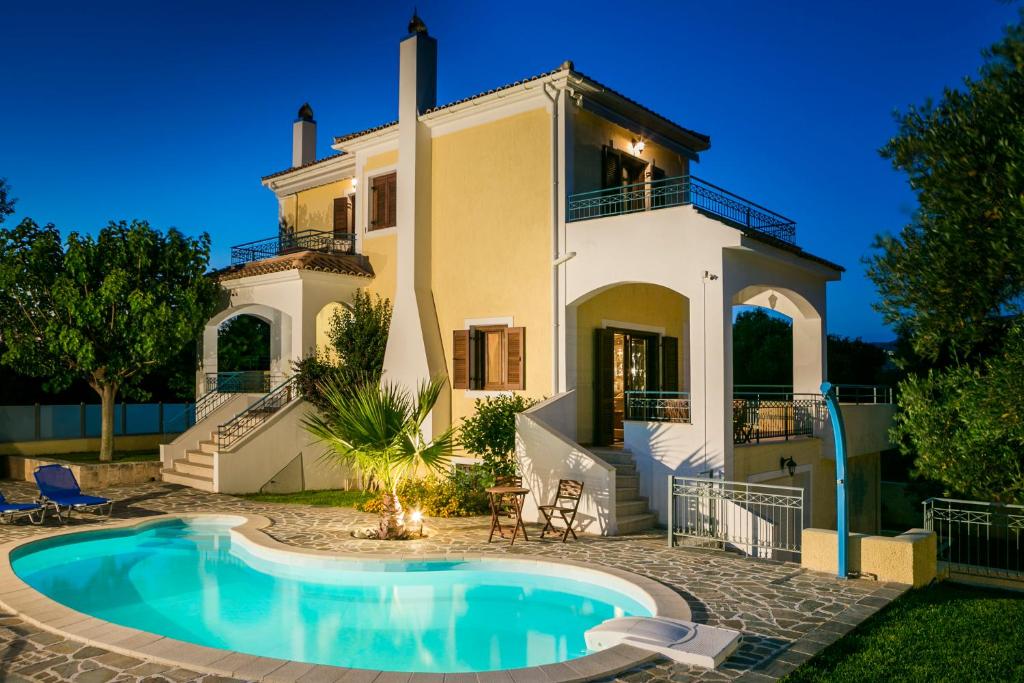 a villa with a swimming pool in front of a house at Villa Cara in Kourkoumelata