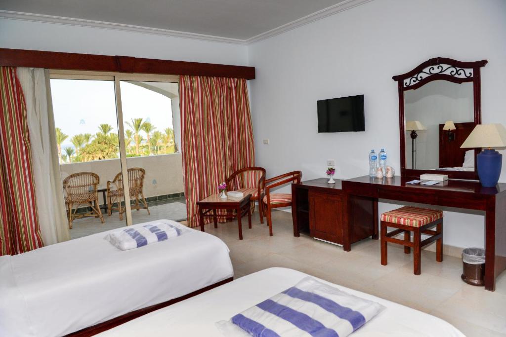 a hotel room with two beds and a vanity and a desk at Brayka Bay Reef Resort in Abu Dabab