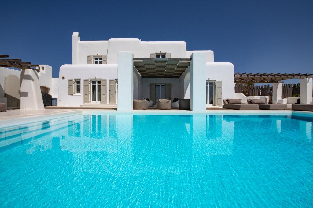 トゥルロスにあるDiles Villas & Suites Mykonosのヴィラの前に広いスイミングプールがあります。