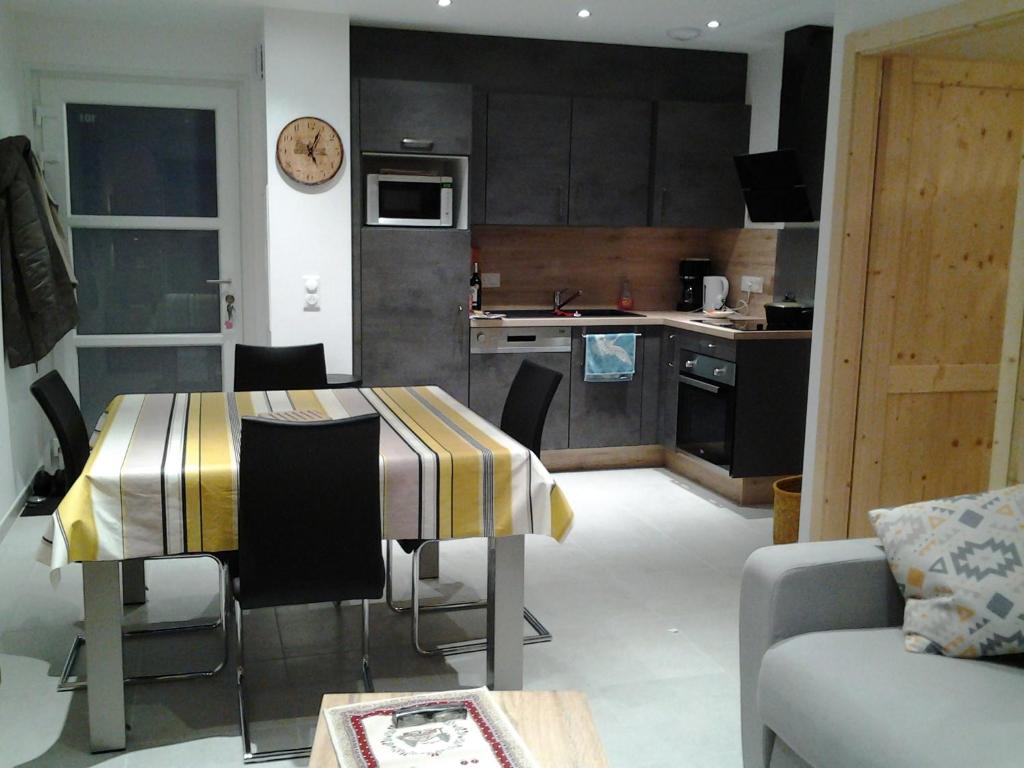 eine Küche und ein Wohnzimmer mit Tisch und Stühlen in der Unterkunft Les balcons la haie des grisselles in Gérardmer