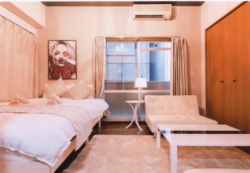 1 dormitorio con 2 camas, silla y ventana en Sakura Sands Hotel en Osaka
