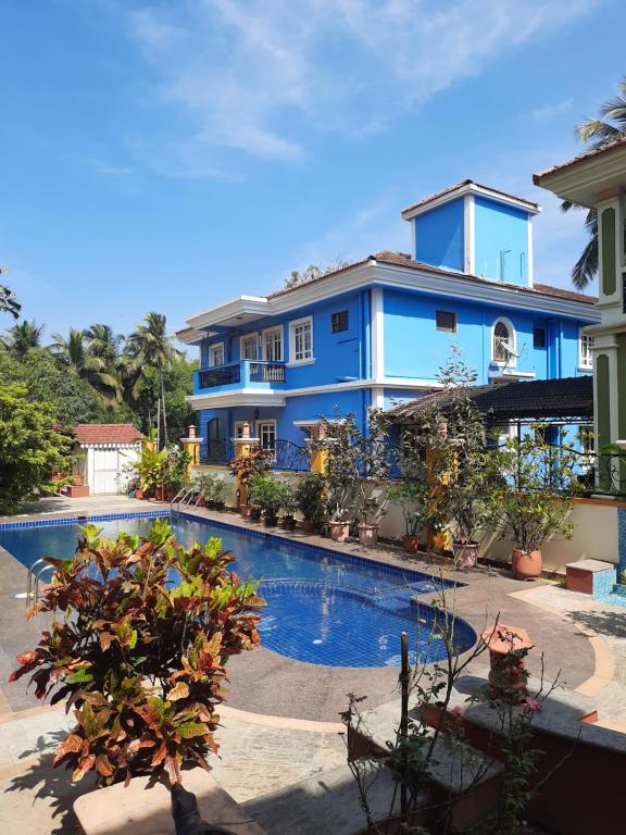 een blauw huis met een zwembad ervoor bij Martins Comfort in Betalbatim