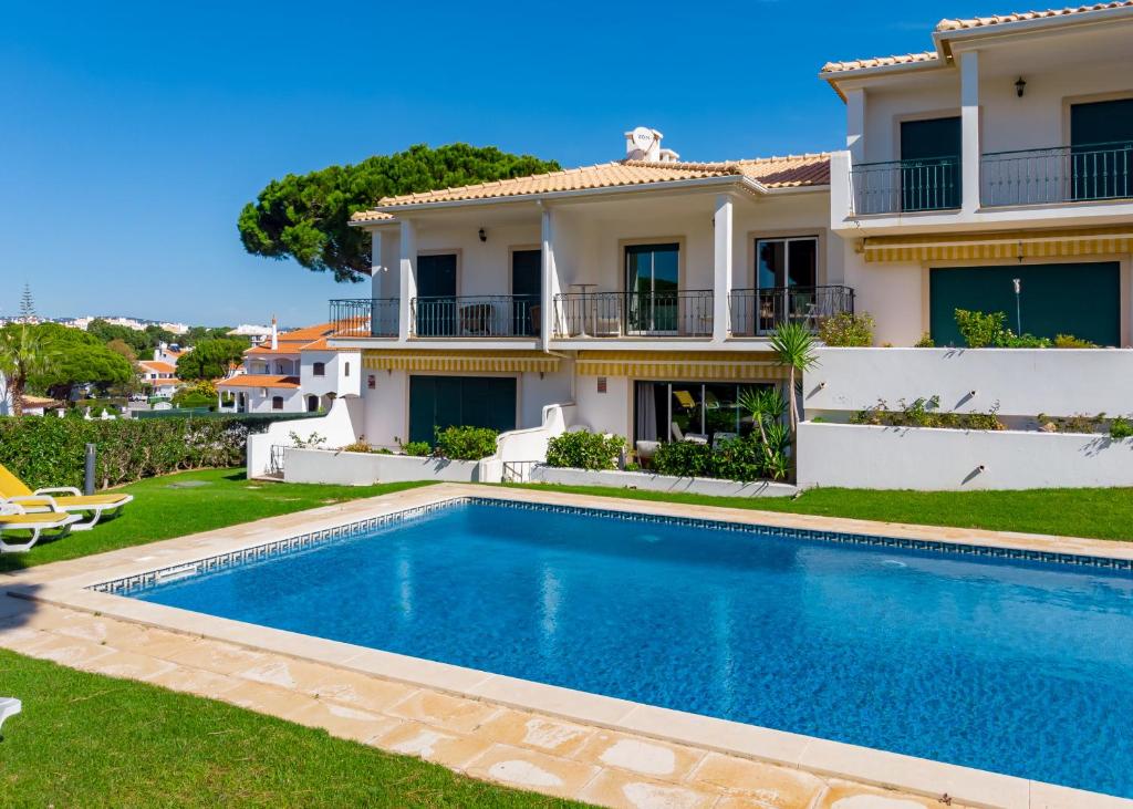 uma villa com piscina em frente a uma casa em Villa Moises em Albufeira