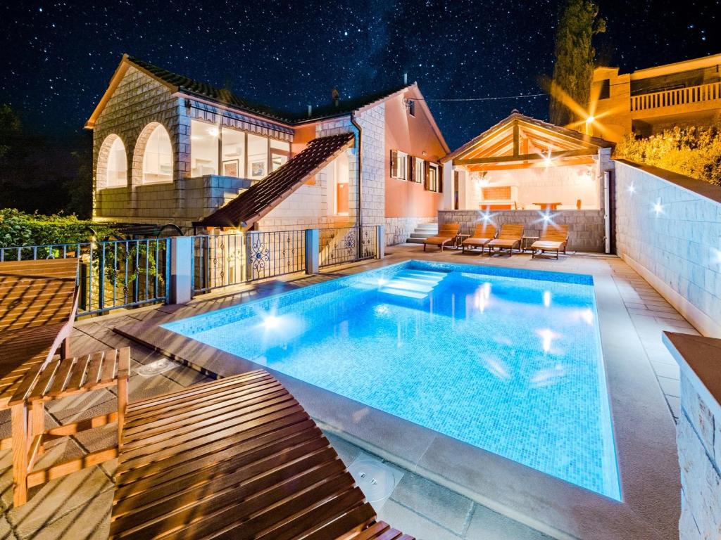 a swimming pool with chairs and a house at Holiday Home Villa Frančeska in Postira