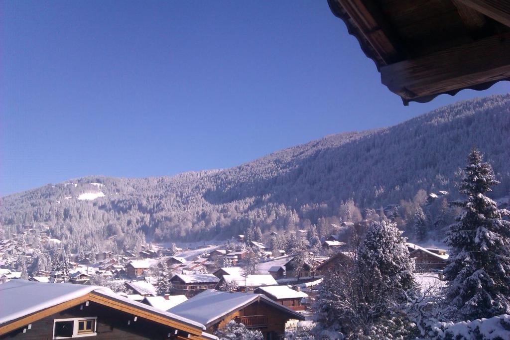 un village enneigé avec une montagne en arrière-plan dans l'établissement 7-28 day stay for best rates- Chalet Les Carroz, aux Carroz d'Arâches