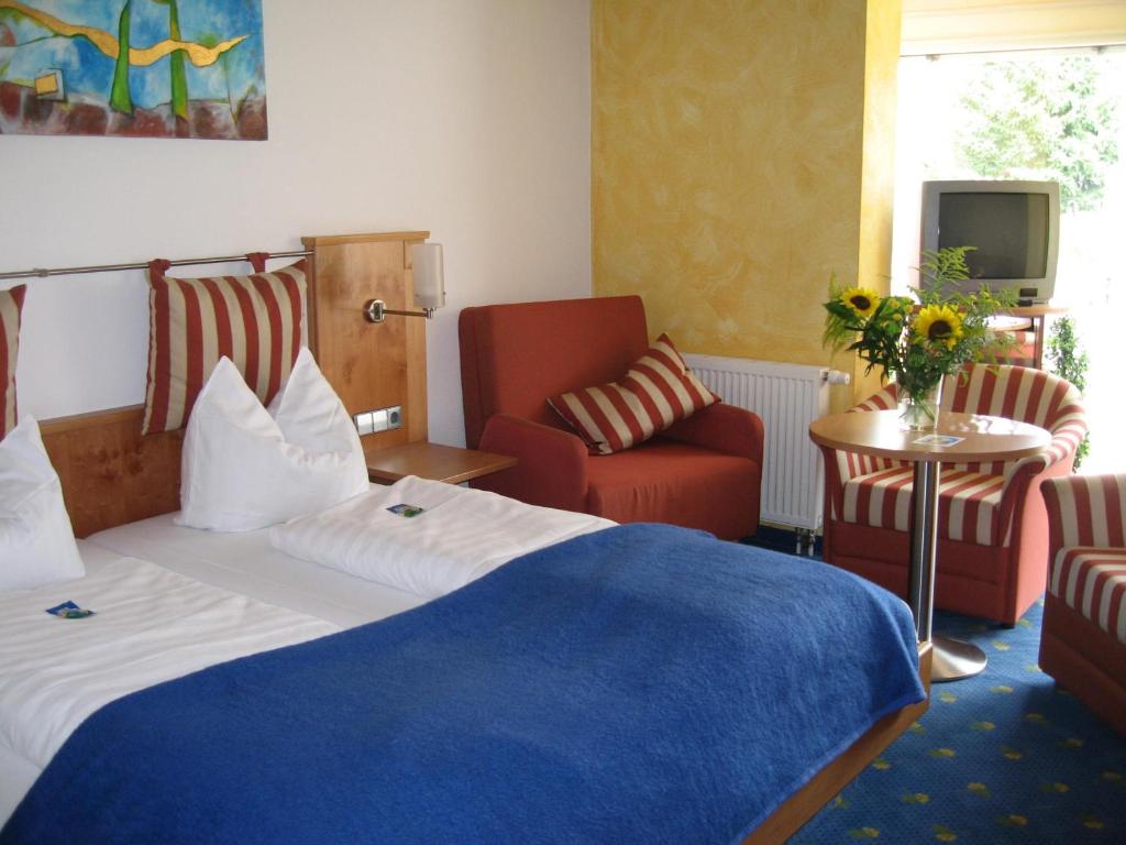 a hotel room with a bed and chairs and a television at Gasthof zum Adler - Wahlwies in Stockach