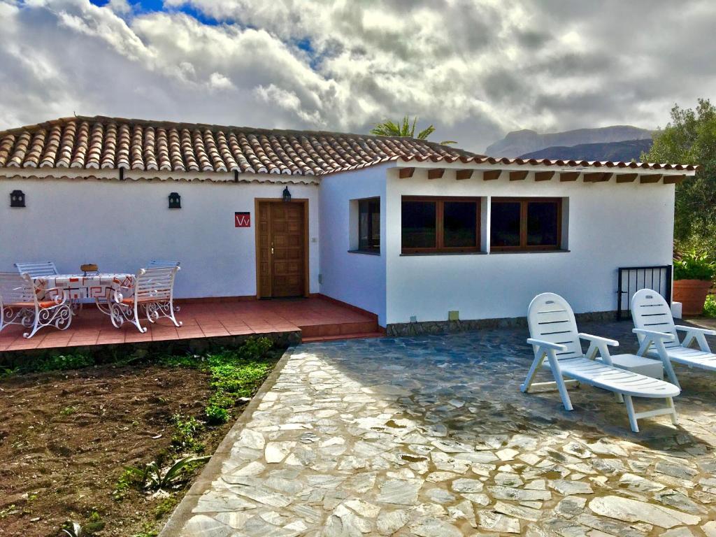 een huis met een patio en een tafel en stoelen bij El Regalo de mis Abuelos in Santa Lucía