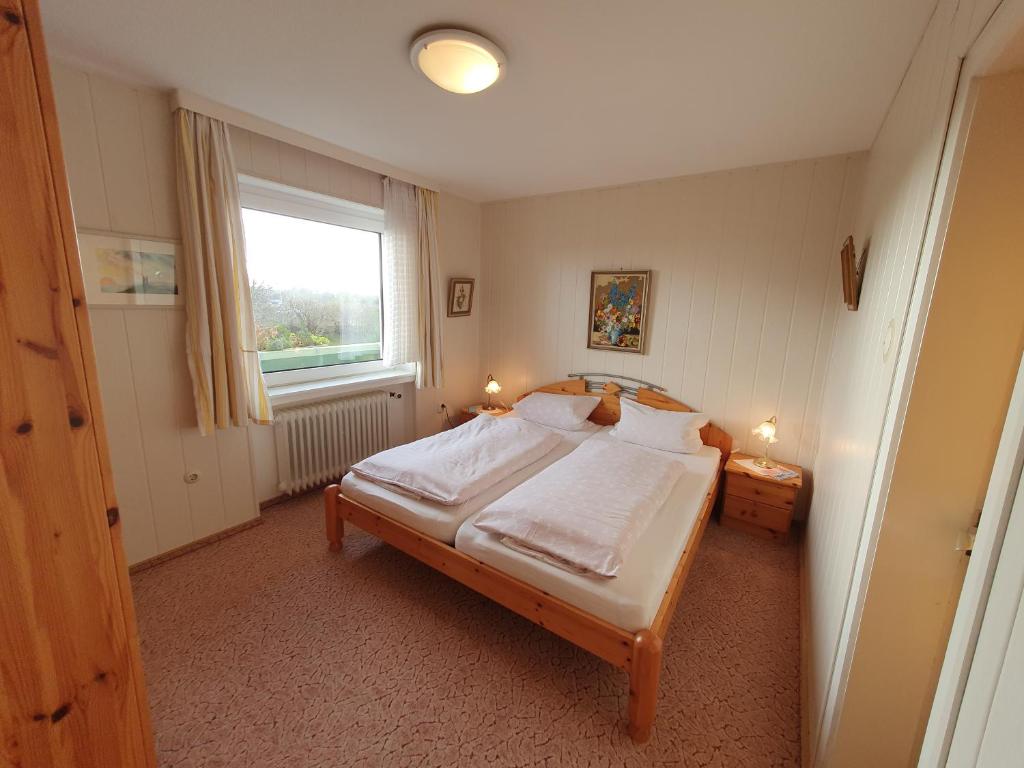 1 dormitorio con cama y ventana en Ferienhaus Flechtner, en Norderney