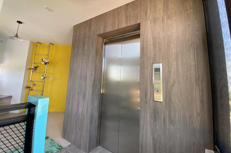a hallway with a metal door in a room at 東莒 找茶複合式民宿-連江縣民宿199號 in Juguang