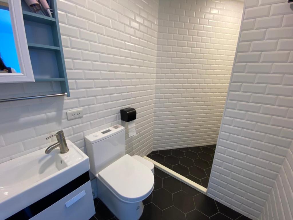 a bathroom with a white toilet and a sink at 東莒 找茶複合式民宿-連江縣民宿199號 in Juguang