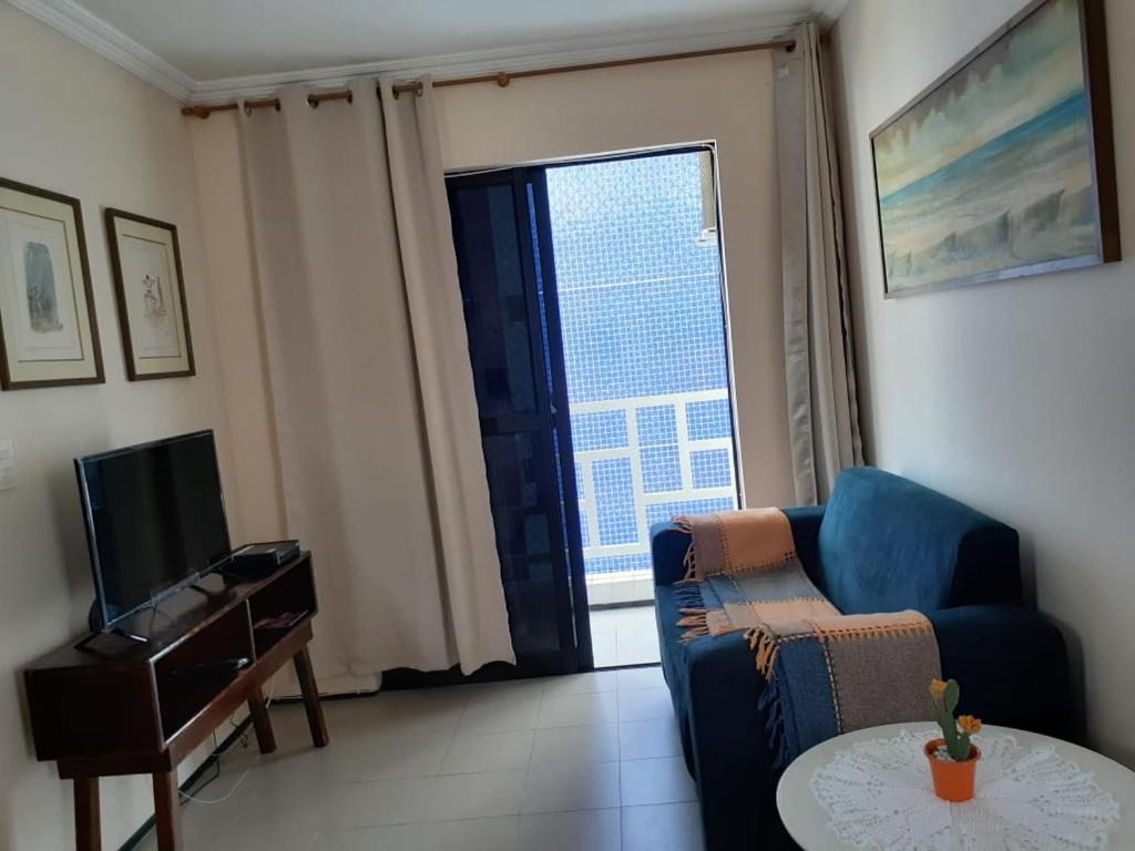 a living room with a blue couch and a television at Apto. 100m da feirinha da beira mar in Fortaleza