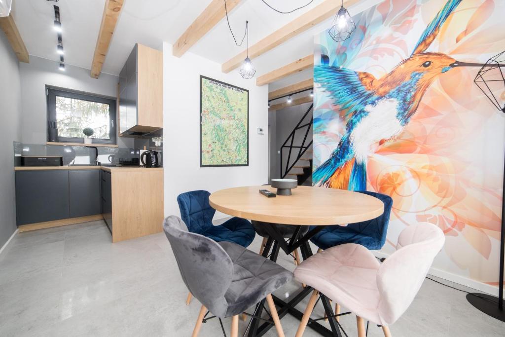 a kitchen and dining room with a table and chairs at Koliberek Apartamenty in Polanica-Zdrój