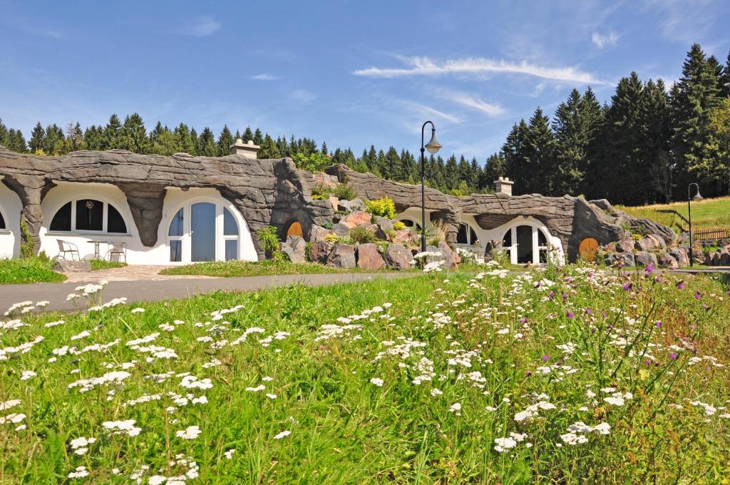 ein Blumenfeld vor einem Steingebäude in der Unterkunft Feriendorf Auenland in Eisfeld