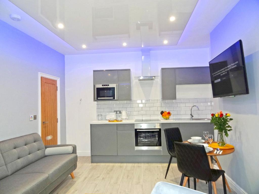 a kitchen and living room with a couch and a table at Sea Nest Apartment by Seaside Llandudno in Llandudno