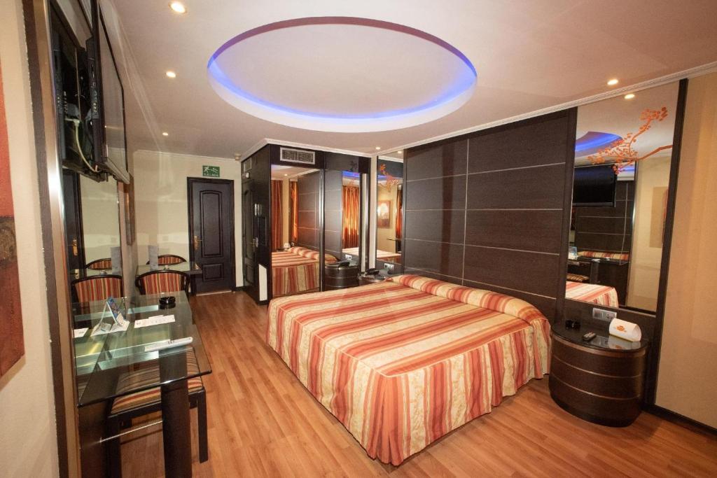 維戈的住宿－Motel Caribe，一间卧室设有一张床和蓝色的天花板
