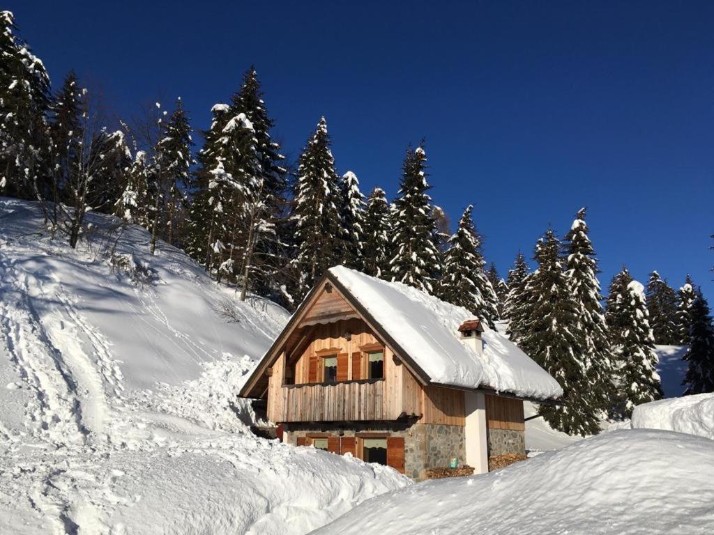 een met sneeuw bedekte hut op een met sneeuw bedekte berg bij Chalet Corone Monte Zoncolan in Sùtrio
