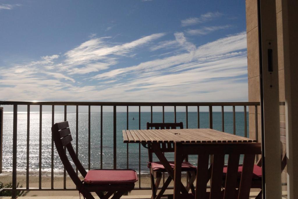 d'une table et de chaises sur un balcon donnant sur l'océan. dans l'établissement Apartamento frente al mar en Calpe con parking para 4 personas, à Calp