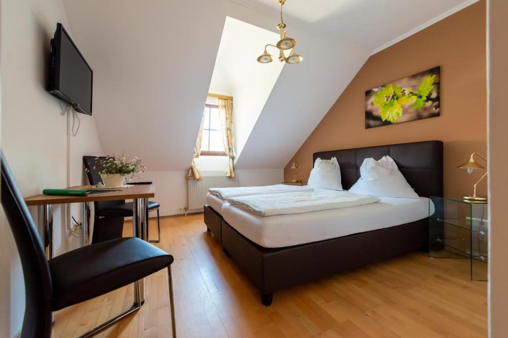 um quarto com uma cama, uma televisão e uma cadeira em Weingut Burger em Kalladorf