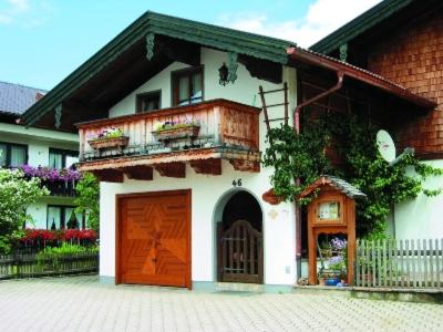 Cette maison blanche dispose d'une porte et d'un balcon. dans l'établissement Haus Mayer - Chiemgau Karte, à Inzell