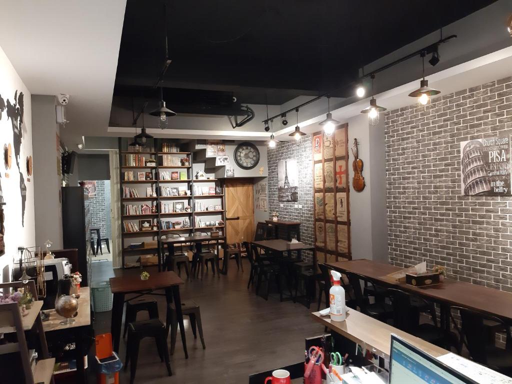 a restaurant with tables and chairs and a brick wall at 清淨背包客棧-民權館Quiet Hostel - Minquan Inn in Tainan