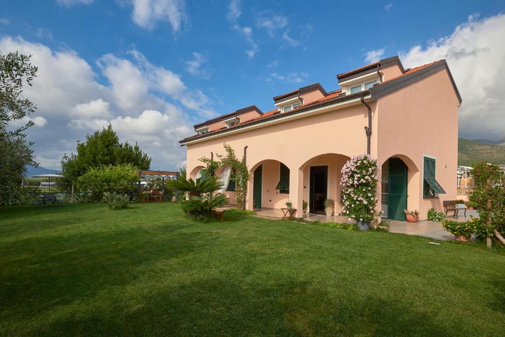 una casa grande con un patio de hierba delante de ella en Agriturismo Casastella, en Ceriale