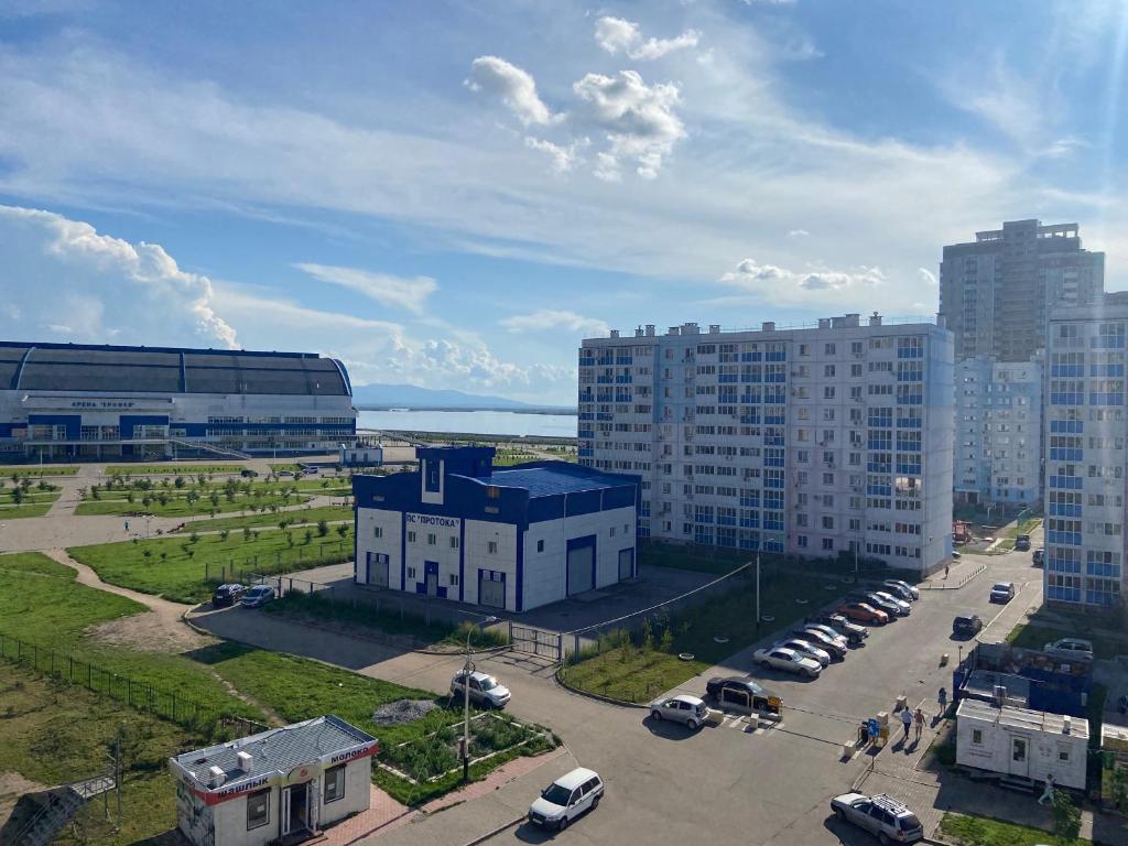 an aerial view of a city with buildings and a parking lot at Apartment Erofey Arena at Sysoeva 8 in Khabarovsk
