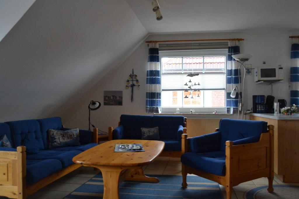 a living room with blue couches and a table at Haus Schimmelreiter in Greetsiel
