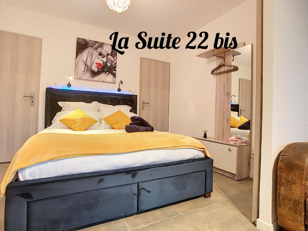 - une chambre dotée d'un lit et d'un panneau indiquant la suite dans l'établissement LA SUITE 22 BIS, à Saint-Sébastien-sur-Loire