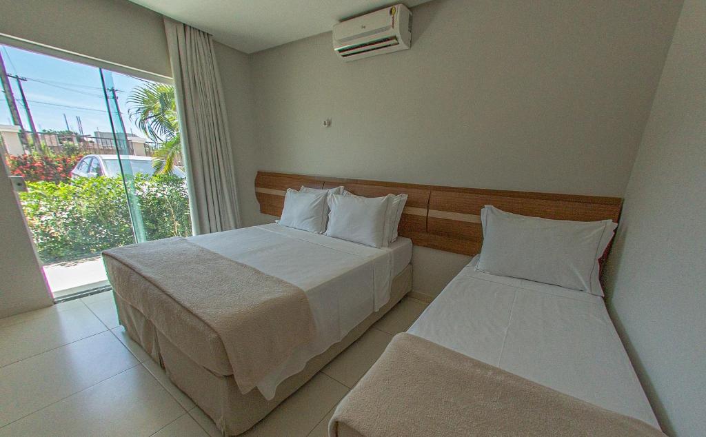 Postel nebo postele na pokoji v ubytování Orquídeas Praia Hotel