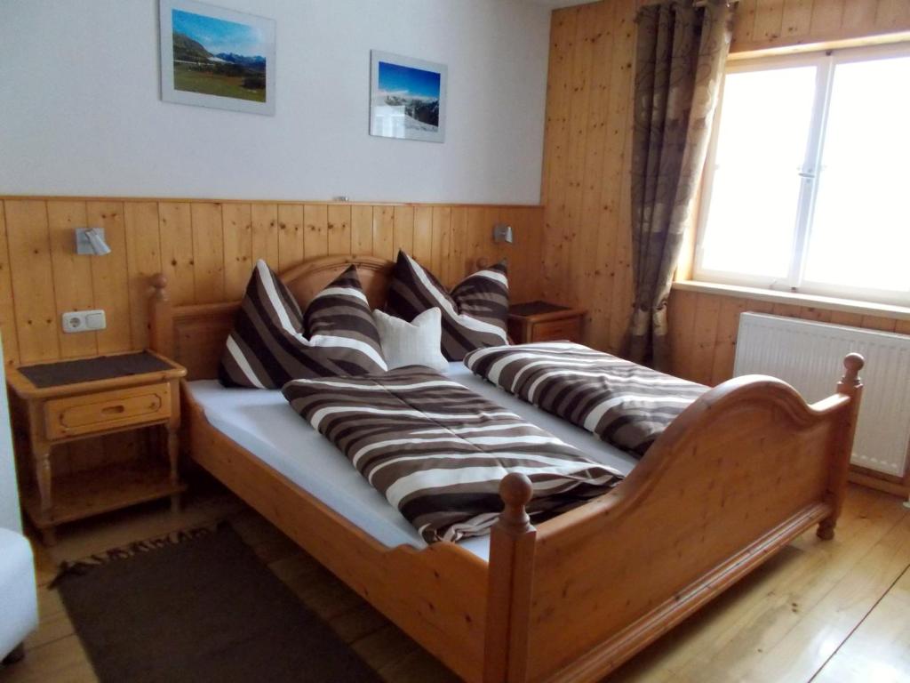 a wooden bed with pillows on it in a room at Haus Klinger in Gaschurn