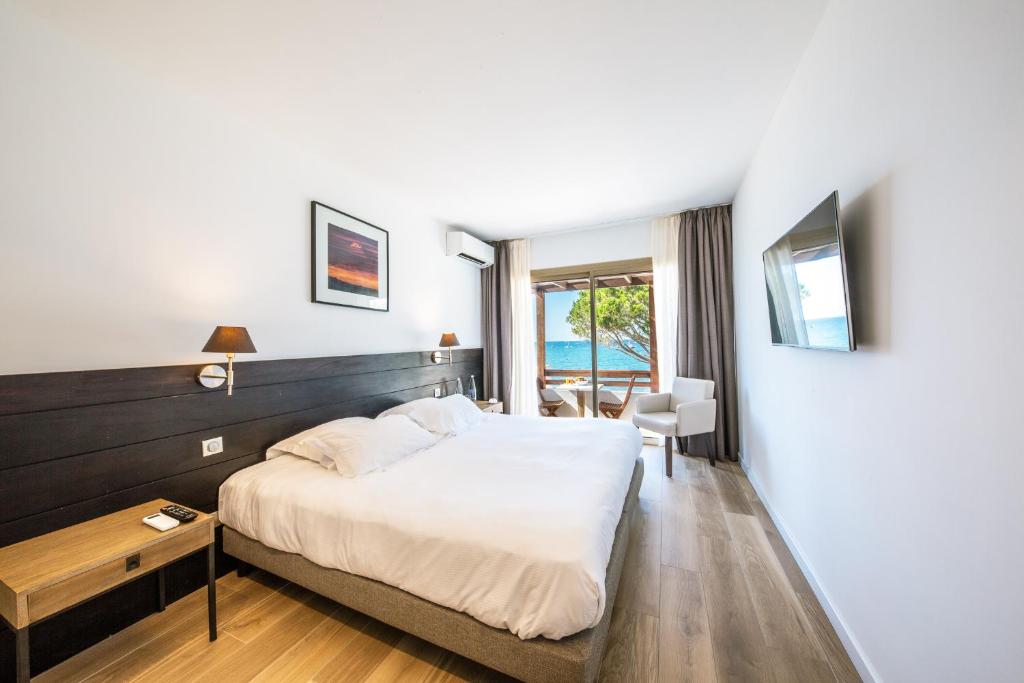 a hotel room with a large bed and a window at Hôtel La Roya in Saint-Florent
