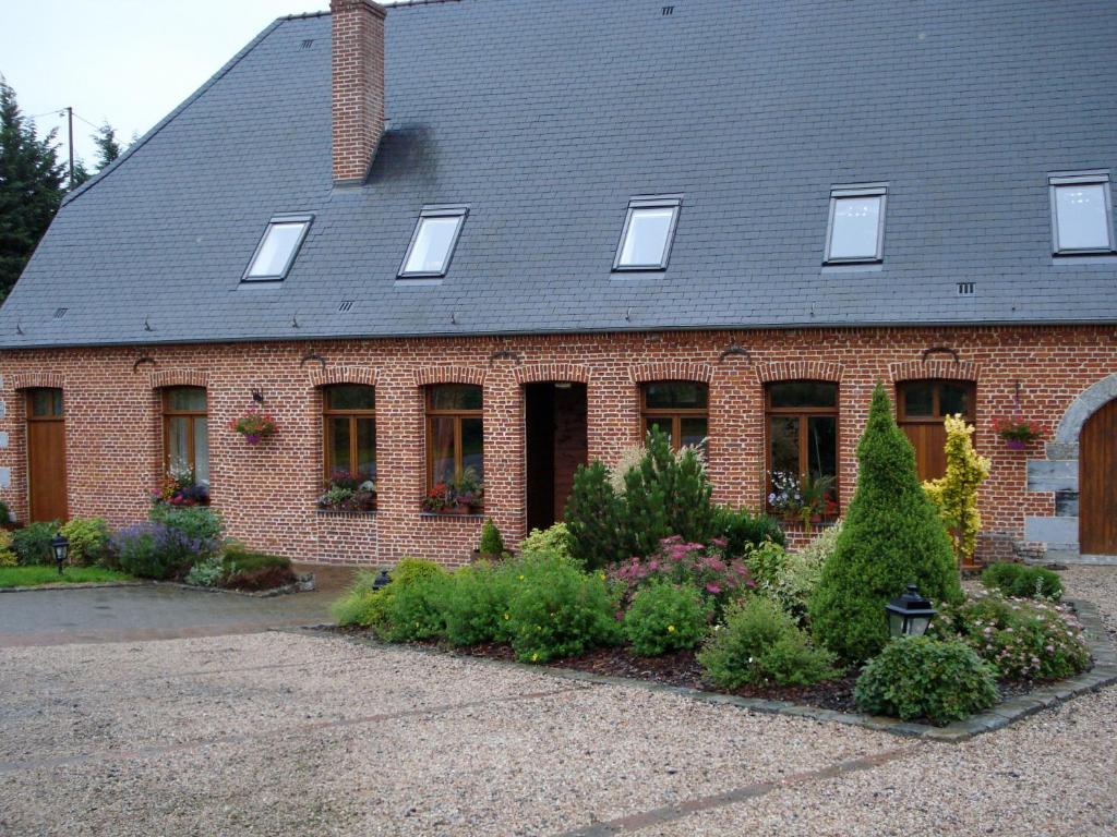 une maison en brique rouge avec une bande de plantes dans l'établissement La Forge De Labbaye, à Liessies