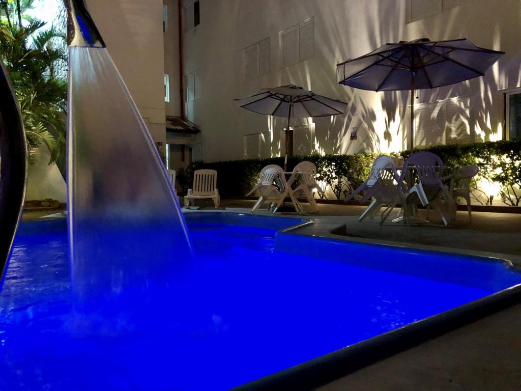 una piscina azul con una fuente de agua en Hotel Des Basques, en Maceió