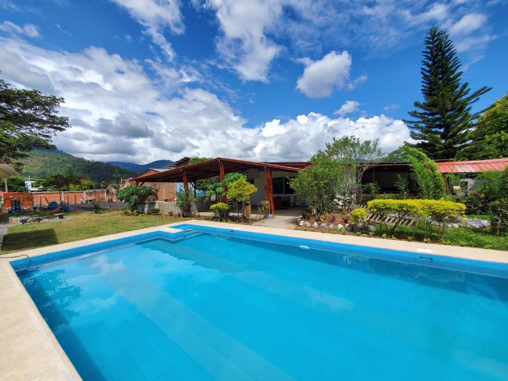 una imagen de una piscina frente a una casa en CASA BLANCA HORTENCIA en Sucúa