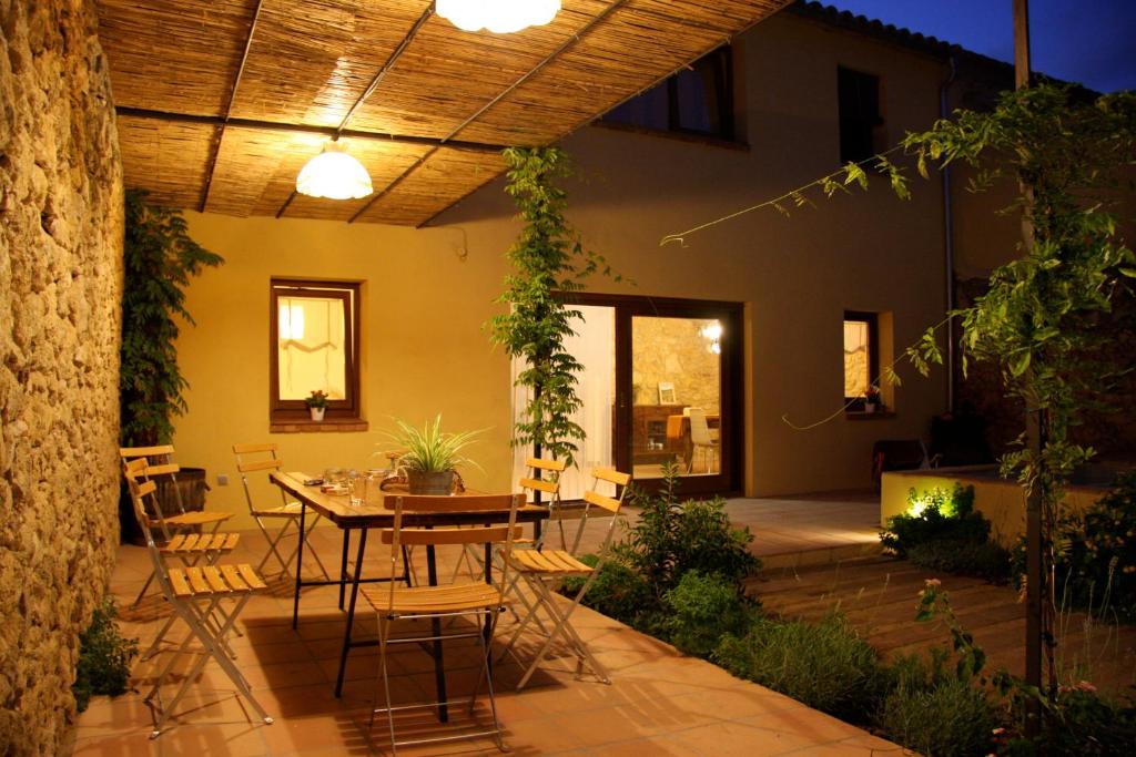 eine Terrasse mit einem Tisch und Stühlen in einem Haus in der Unterkunft Ca l'Helena in Castellet