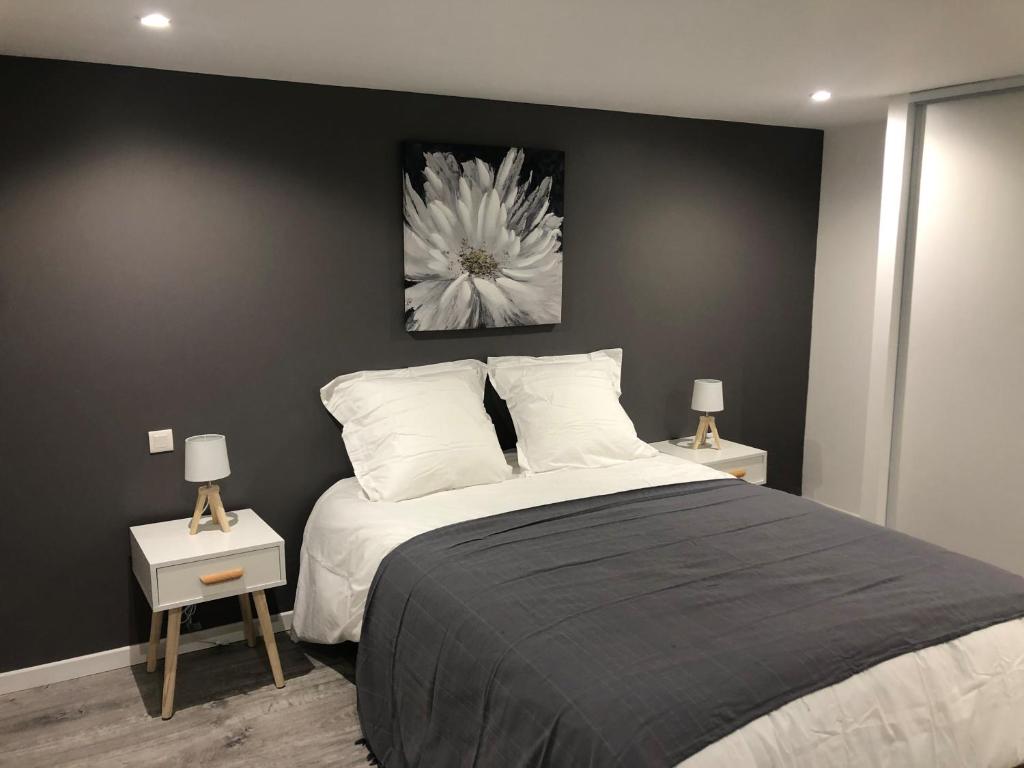 - une chambre avec un grand lit et 2 tables avec des lampes dans l'établissement Jardin de la Béchade, à Bordeaux