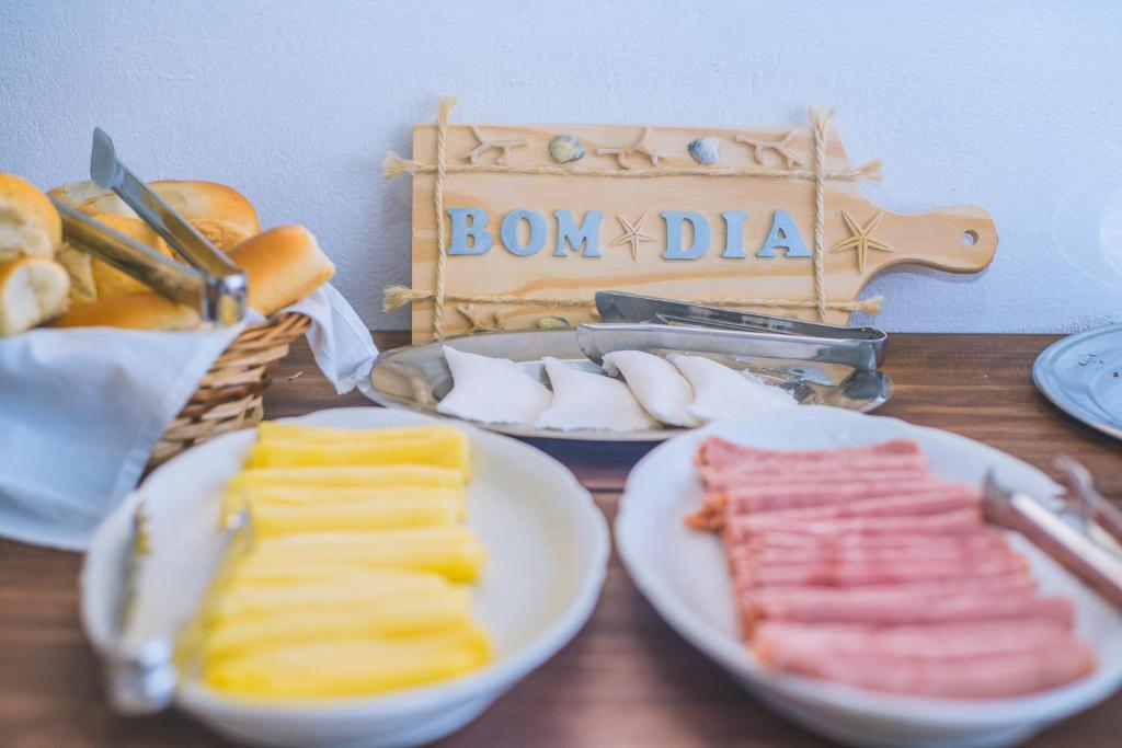 a table with plates of food and a sign that says bon appetizers at Pousada Casa Boa Milagres in Barra do Camaragibe