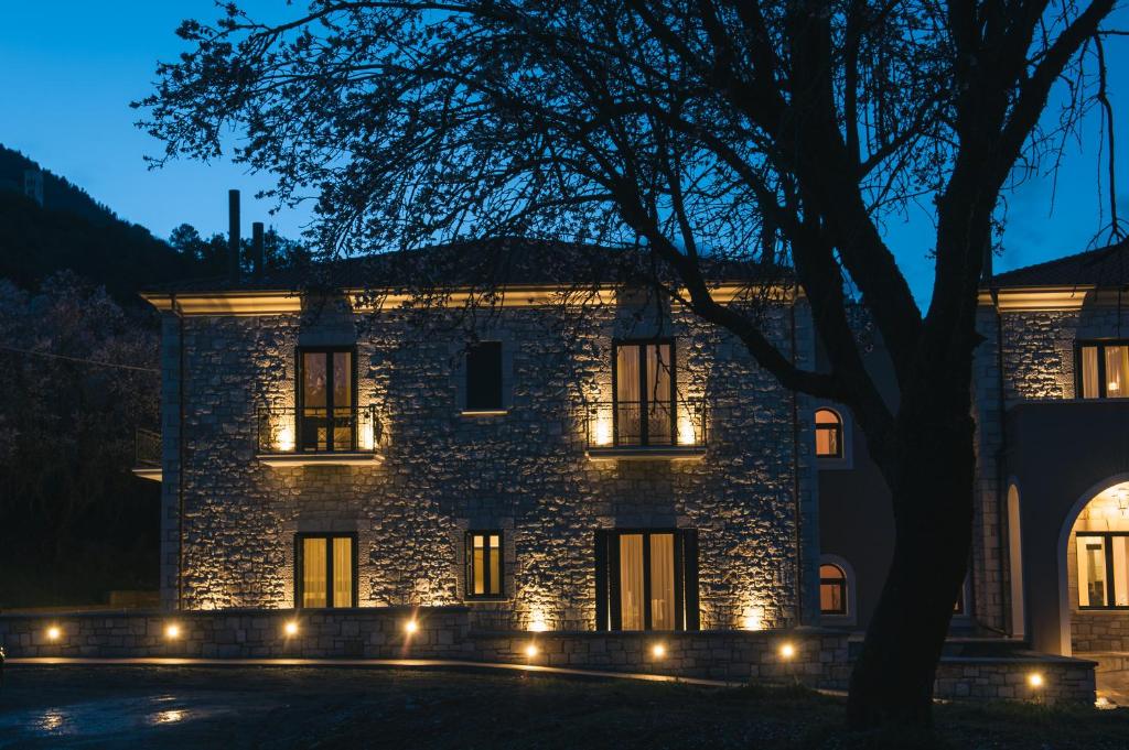 una casa de piedra con luces delante en Levidi Suites, en Levidhion