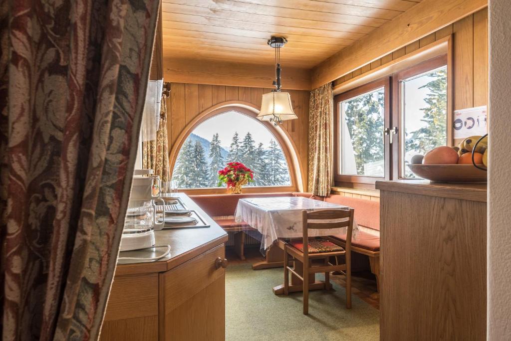 eine Küche mit einem Tisch und einem Esszimmer in der Unterkunft Kleine Gartenwohnung Haus Forelle in Wolkenstein in Gröden