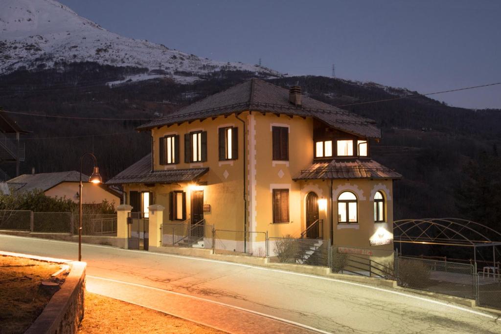 a house on a street with a mountain in the background at Camere Villa Lunardini in Frassinetto
