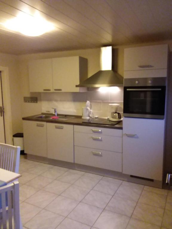 a kitchen with white cabinets and a stove top oven at Haus Rose in Nortorf