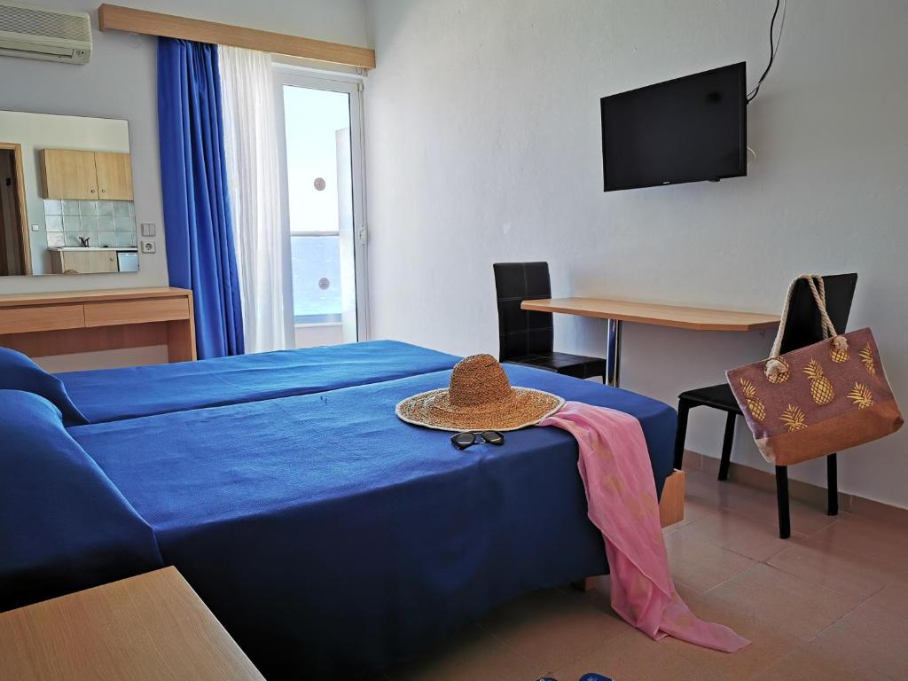a bedroom with a blue bed with a hat on it at Europa Hotel in Rhodes Town