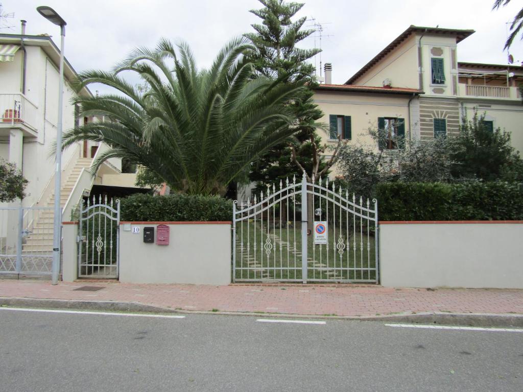 ein Tor vor einem Haus mit einer Palme in der Unterkunft Casa Rosy in San Vincenzo