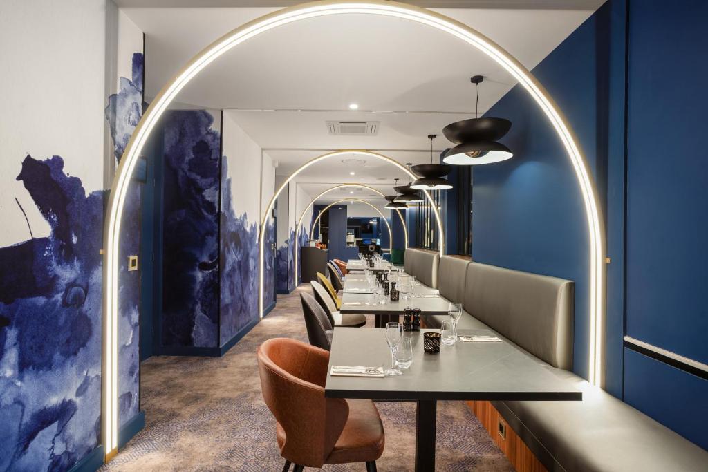 une salle à manger avec une arche et une longue table dans l'établissement Appart'City Collection Genève Aéroport - Ferney Voltaire, à Ferney-Voltaire