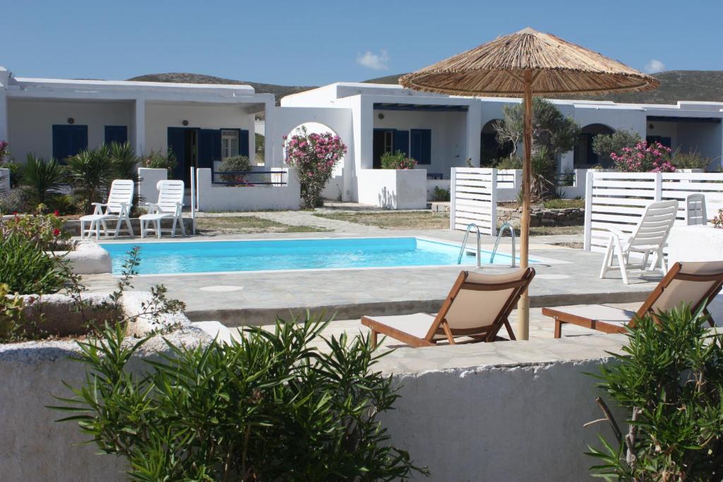 una villa con piscina, sedie e ombrellone di Naoussa Hotel Paros by Booking Kottas a Naoussa