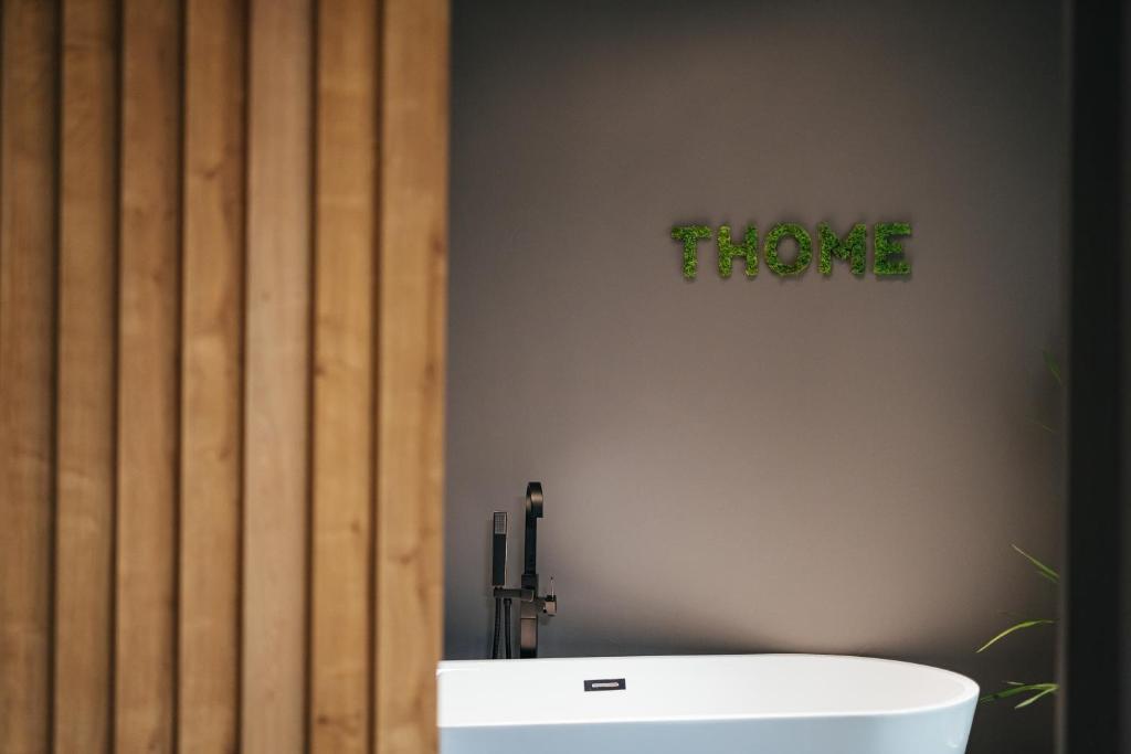 uma casa de banho com banheira e uma placa que diz prove em Thome Arena Residence em Cluj-Napoca