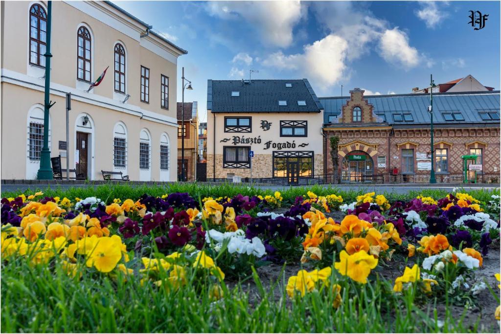 un jardín de flores frente a un edificio en Pásztó Fogadó en Pásztó