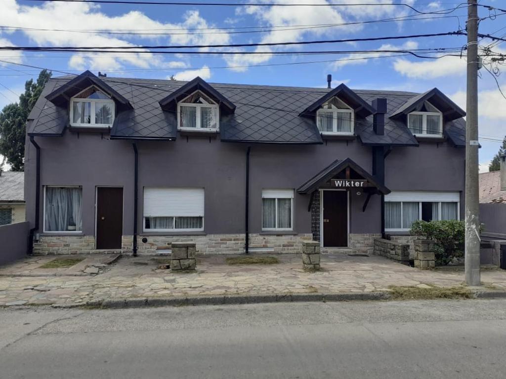 una casa morada con techo gris en Hosteria Wikter en San Carlos de Bariloche