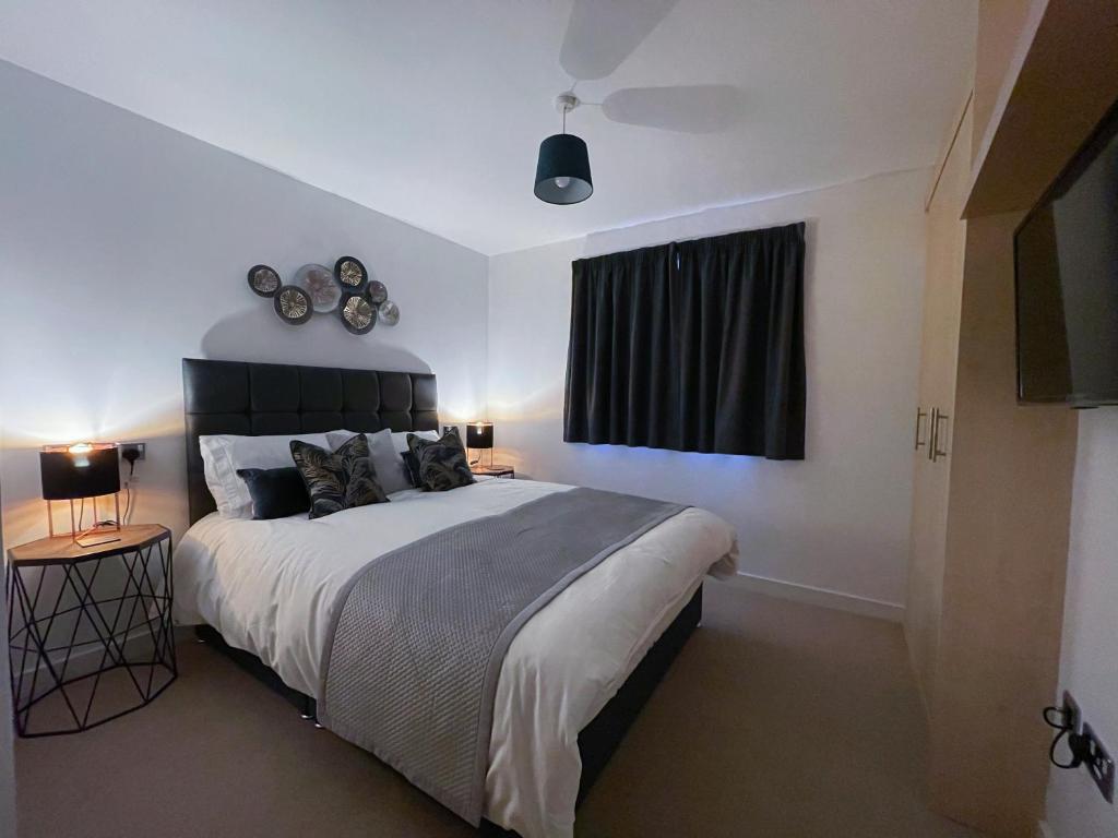 um quarto com uma cama grande e uma janela em Station Side Penthouse em Wolverhampton