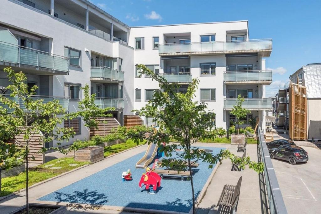 un apartamento con parque infantil frente a un edificio en Modern City Apartment - Lillestrøm-Strømmen, en Lillestrøm